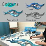 Image features three modern wave-shaped metal wall art pieces in aqua, blue, and silver, each with an orb accent, under the heading “Colours.” The lower section shows an artist painting one of the aqua wave sculptures in a studio, with brushes, paints, and other metal pieces arranged on the table, highlighting craftsmanship and color options.