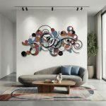 Contemporary living room featuring a modern abstract metal wall art sculpture with colorful geometric shapes, mounted above a curved sofa and wooden coffee table.