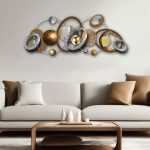 Orbit sculpture with metallic rings in silver, gold, and bronze tones, mounted above a cream-coloured contemporary sofa