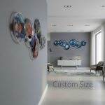 A modern living space with grey walls features abstract metal wall art made of colorful, overlapping circular shapes. The art is displayed both along a hallway and on the far wall of a bright, minimalistic room with sleek furniture, a white sideboard, and large windows. The words "Custom Size" appear on the floor in the foreground.