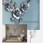 The image features a beautifully crafted, metallic wall art of roses with detailed leaves, set against a soft blue background. The artwork emphasizes the handmade, artisanal quality of the piece, highlighting its intricate design and elegant finish. The text "HAND-CRAFTED" is displayed nearby, underscoring the craftsmanship involved. The overall aesthetic combines modern artistry with a touch of nature-inspired elegance, making it a perfect decorative piece for sophisticated interiors.