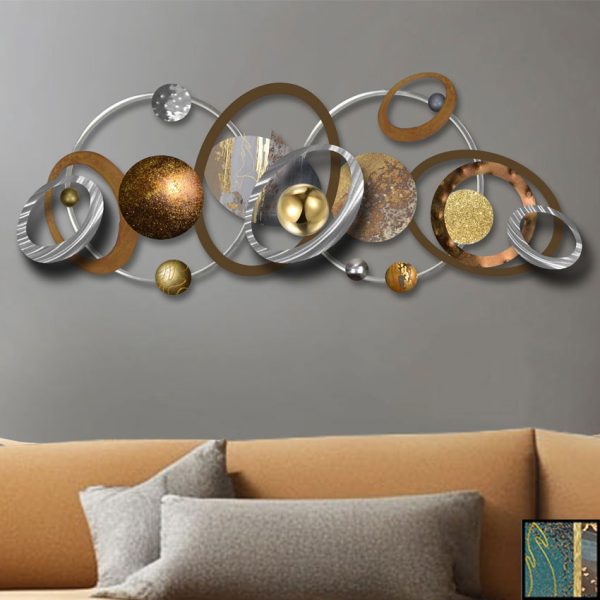 "Orbit – A handcrafted abstract metal wall sculpture featuring layered circles in gold, teal, copper, and silver tones, styled above a modern neutral sofa in a minimalist living room."