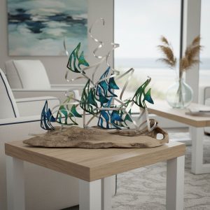 Driftwood metal sculpture featuring abstract blue and green fish, displayed in coastal living room. Unique handmade driftwood art, perfect for beach house decor, bathroom art, or nautical home accent. Modern ocean-inspired centerpiece sits on a natural wood table with light decor, ocean view, and serene atmosphere, highlighting artisanal craftsmanship and stylish design.